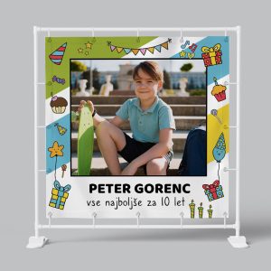 Bright young boy smiling with skateboard at outdoor celebration, colorful party decorations and gift.