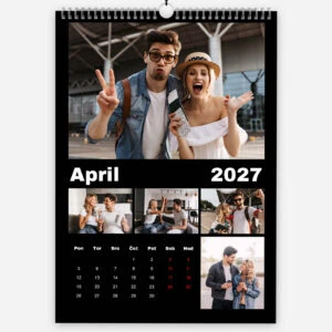 Young couple at train station making funny faces and gestures in April 2027 calendar.