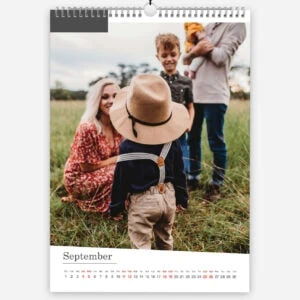 Family enjoying outdoor photo session in a green field during September.