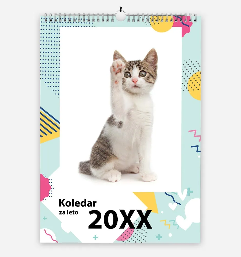 Cute kitten raising paw on colorful calendar with 20XX date.