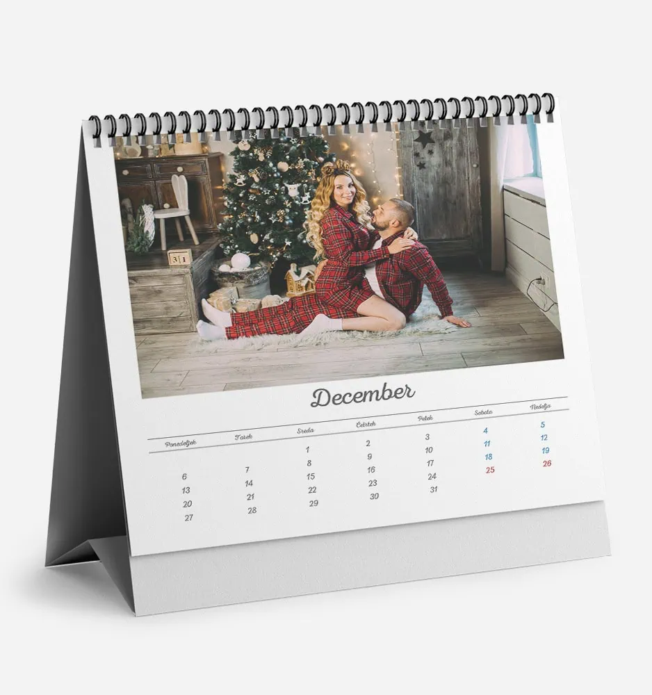 bela_dilema_1 Festive holiday scene with two women in Christmas pajamas by a decorated tree.