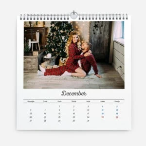Festive Christmas scene with a woman and child in front of decorated tree.