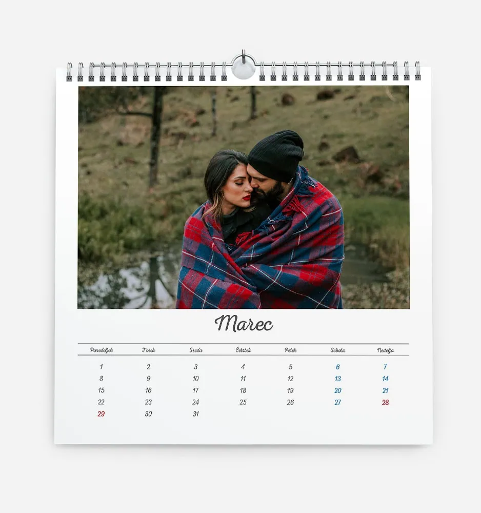 Couple wrapped in a blanket outdoors in a scenic natural setting.