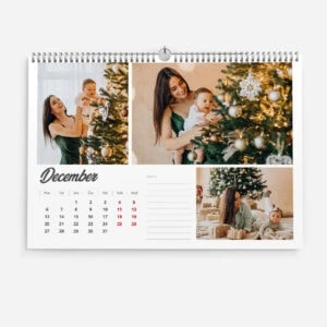 Family celebrating Christmas with decorated tree and children opening gifts.
