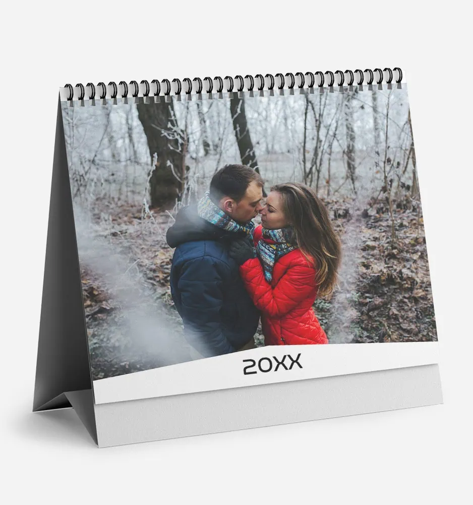 Couple embracing outdoors in winter with trees in background.