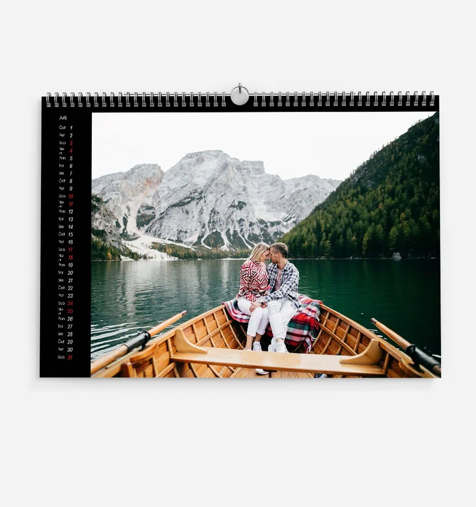 Couple kissing in a boat on a mountain lake with scenic landscape.