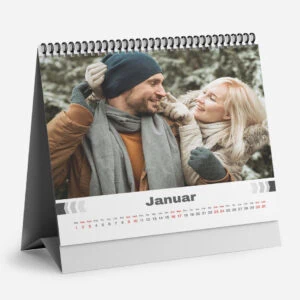 Happy couple enjoying winter outdoors in January with a calendar in the background.